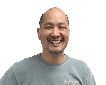 A smiling man wearing a blue shirt