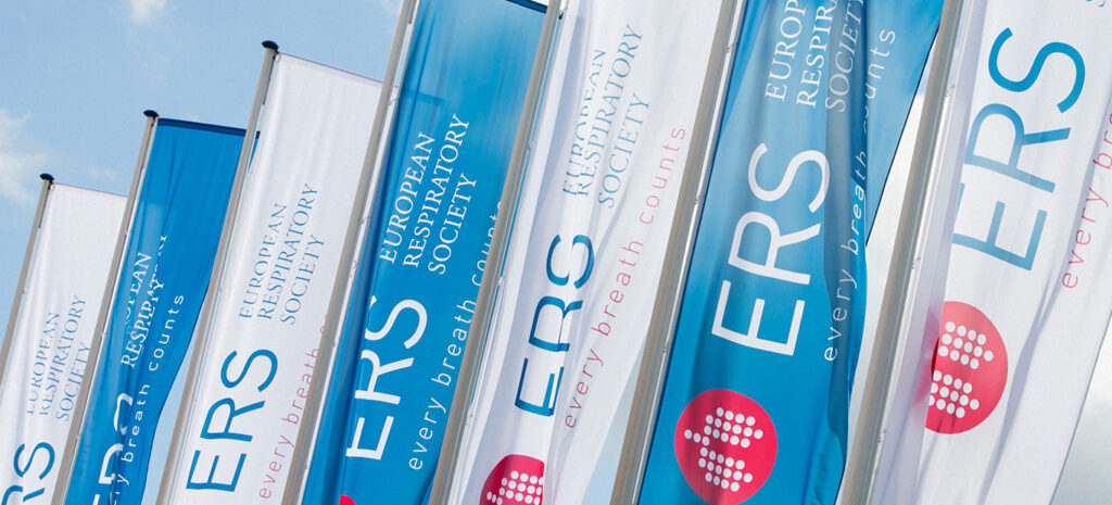 A row of white and blue flags against a clear blue sky. The flags read ERS Eruopean Respiratory Society.